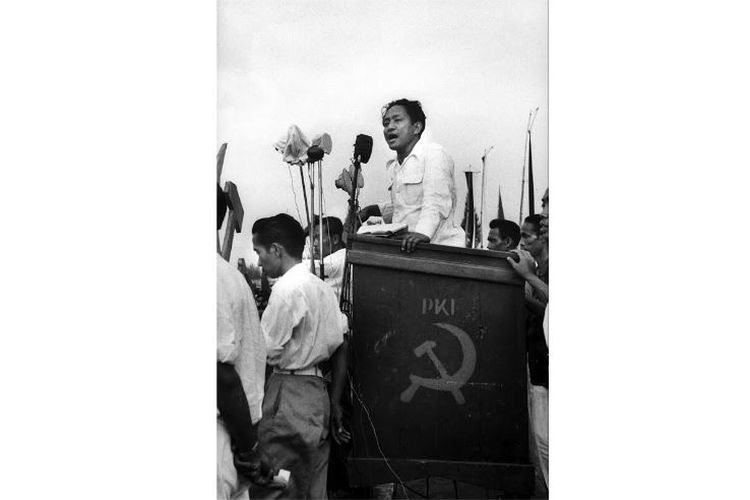 ภาพชายคล้ายประธานาธิบดีโจโก วีโดโด ยืนในการปราศรัยของไอดิต ผู้นำพรรคคอมมิวนิสต์อินโดนีเซียปี 2498
