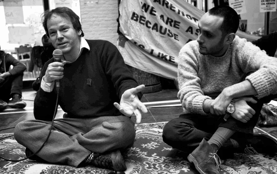 David Graeber, left, speaks at the Maagdenhuis occupation at the University of Amsterdam in March 2015. (Wikimedia Commons / Guido van Nispen)