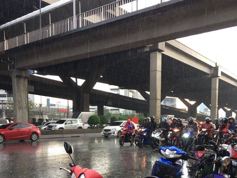 มอเตอร์ไซค์จอดหลบฝนใต้สะพานลอยคนข้ามถนนวิภาวดีรังสิต (ที่มาภาพ: เพจเฟสบุค JS100, 2018)